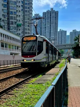 Source photograph of a Hong Kong tram on its tracks among buildings.